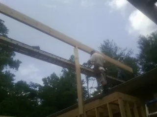 Carpenter setting a ridge beam over a new addition frame — Ice Dam Removal by Roofing Brothers in Winona