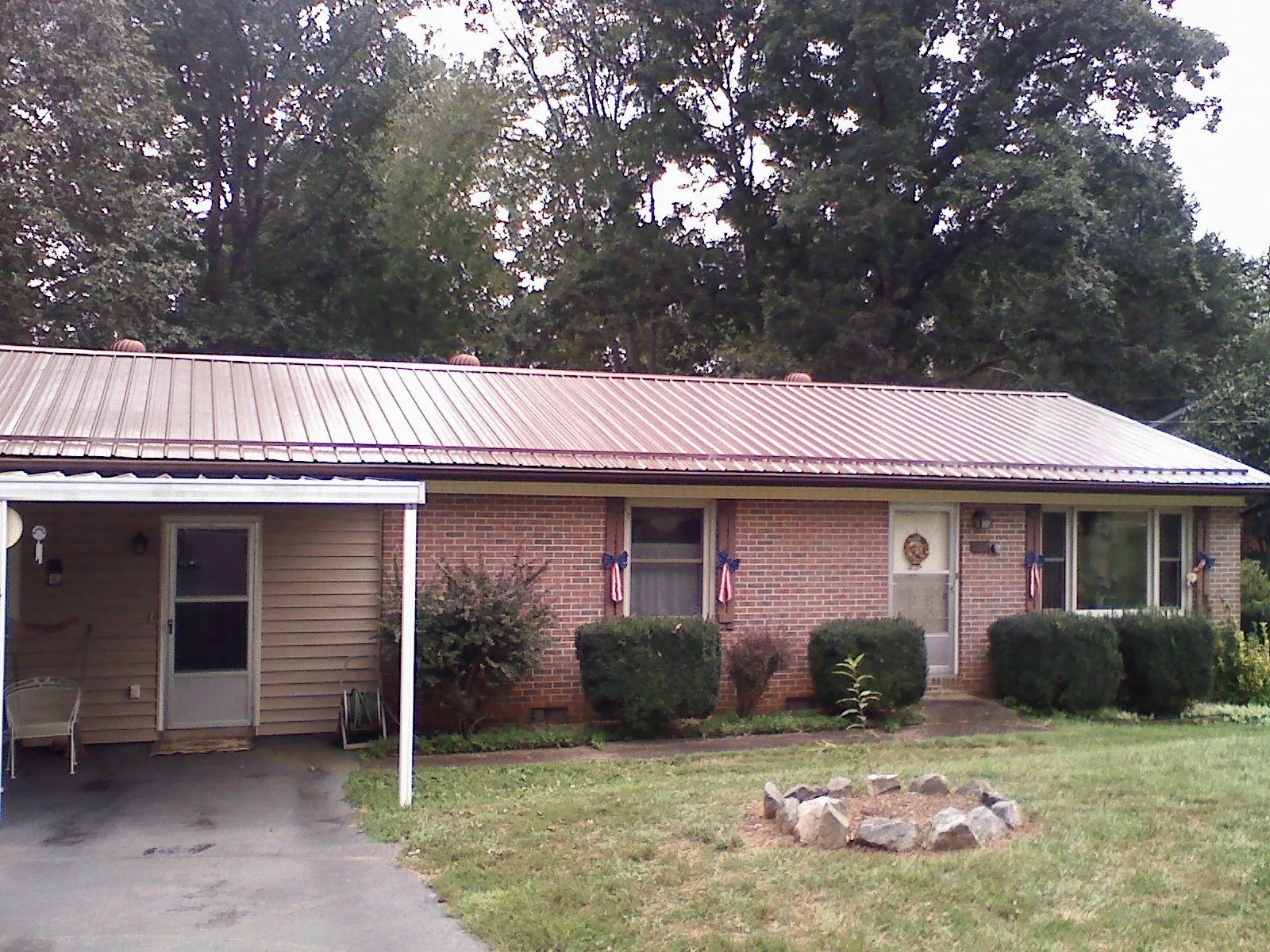 Bronze metal roof and carport on a brick ranch home — Roof Repair work by our crew in Winona